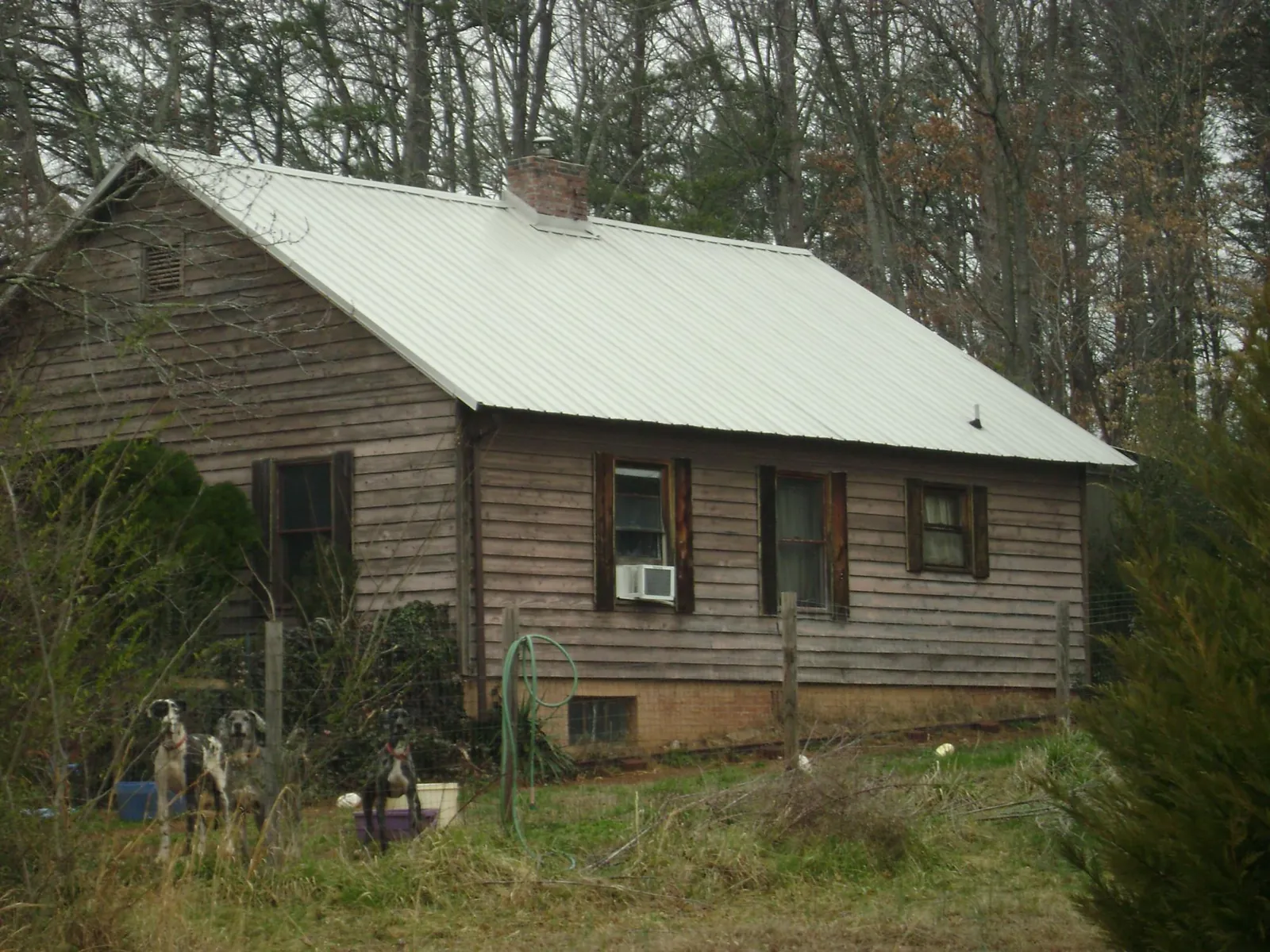 White metal roof on an old wood sided farmhouse, from a Metal Roof Installation job in Osage City